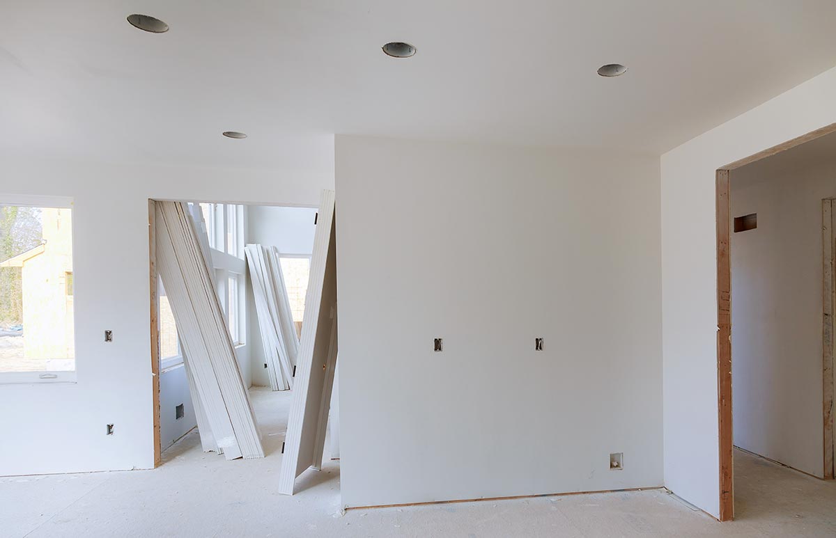 Smooth drywall walls and ceiling in a room under renovation